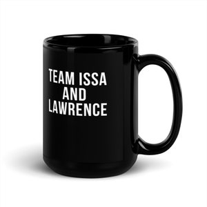 Może przedstawiać: Czarny kubek ceramiczny z białym napisem "TEAM ISSA AND LAWRENCE".
