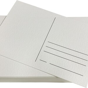 May include: A stack of blank white postcards with a textured surface. The postcards have a space for an address and a message on the back.