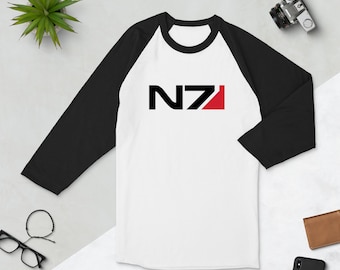 May include: A white and black baseball style t-shirt with a red and black N7 logo on the front.