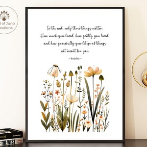 Pode incluir: Uma impressão de arte imprimível branca com uma citação de Buda sobre o amor, a vida gentil e o deixar ir. A citação é cercada por uma ilustração de aquarela de um campo de flores silvestres em tons de verde, amarelo e rosa.