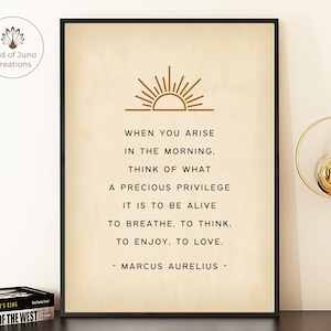 May include: A beige printable wall art print with a gold sun graphic and a quote by Marcus Aurelius: "When you arise in the morning, think of what a precious privilege it is to be alive, to breathe, to think, to enjoy, to love."