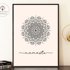 May include: Black and white mandala art print with the word "namaste" in a cursive font. The artwork is framed in a black frame and set against a light pink background. The upper left corner has a logo that says "Bird of Juno Creations".