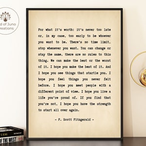 Può includere: Stampa incorniciata con una citazione di F. Scott Fitzgerald su sfondo color crema. Il testo inizia: "Per quello che vale: non è mai troppo tardi..." La stampa è in una cornice nera e presenta il logo Bird of Juno Creations.