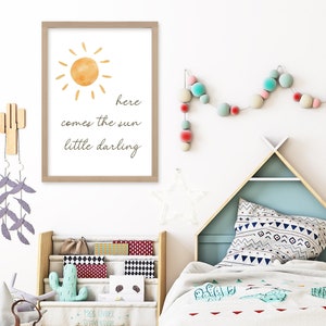 May include: A framed print with a watercolor sun illustration and the text "here comes the sun little darling." The room features a wooden bookshelf, a teepee-shaped bed frame, and decorative cactus wall hangings.