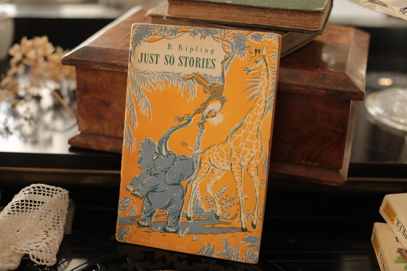May include: A vintage children's book titled "Just So Stories" by R. Kipling. The cover features a colorful illustration of an elephant, a giraffe, and a monkey in a jungle setting.