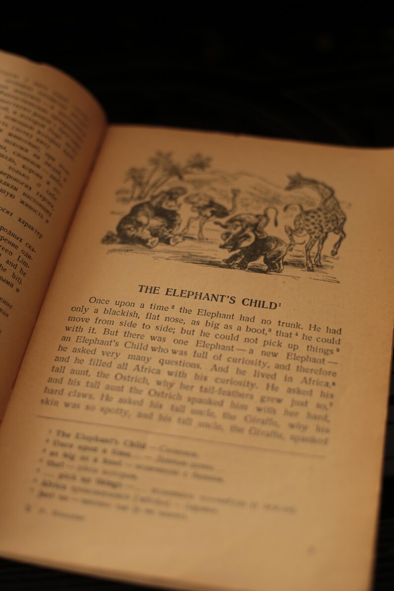 May include: An open book with a black and white illustration of an elephant with a trunk and other animals. The text on the page reads "THE ELEPHANT'S CHILD".