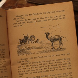 May include: An illustrated children's book page with black and white drawings of a camel, an ox, a horse, and a dog. The text reads "Humph!" said the Camel; and the Dog went away and told the Man. Presently the Ox came to him, with the yoke on his neck and said, "Camel, O Camel, come and plough like the rest of us."  GOT HIS HUMP and it tells how the Camel when the world was so new ginning to work for Man, and in the middle of a De to work. So he ate sticks and nothing more. He when somebody spoke to him and nothing more. hi on Monday morning, da bridle is his mouth, and ost and work like the rest "Humph!" said the Camel; and the Ox went away and told the Man. At the end of the day the Man called the Horse and the Dog and the Ox together, and said, "Dear Friends, I'm very sorry for you, but the Camel in the Desert can't work. He has not come here by now and I am going to leave him alone. So you must work double time to do his work, 100." Haare the Dog and the Ox were very angry, and of the Desert; and the Laughed