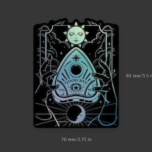 Puede incluir: Pegatina holográfica con una ilustración en blanco y negro de una tabla Ouija con las palabras "Good Bye" en ella. La tabla está rodeada por dos manos, una luna creciente y un sol. La pegatina mide 90 mm por 70 mm.