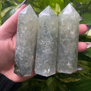May include: Three green and white crystal points with black inclusions. The points are polished and have a smooth, glassy finish.