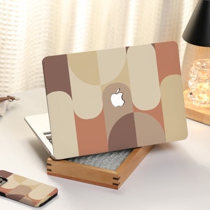 以下が含まれることがあります： ブラウン、ベージュ、オレンジの幾何学模様のケースをつけたラップトップコンピューター。ケースには白いアップルのロゴがあります。同じ模様のマッチングする携帯電話ケースも表示されています。画像の下部に「iPhone case < Glossy >」と書いてあります。