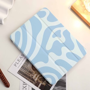 May include: A light blue tablet case with a white abstract swirl pattern.