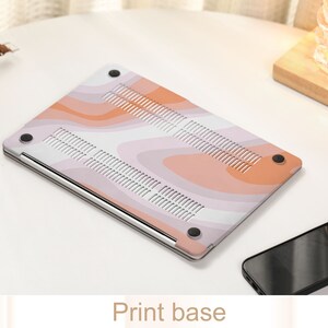 May include: A pink and orange laptop skin with a wavy abstract pattern. The skin is designed to fit a laptop and has a smooth, matte finish.