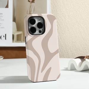 Op de afbeelding: Een beige en witte telefoonhoes met een golvend abstract patroon. De hoes is ontworpen voor een iPhone met een camerabult.