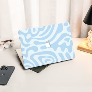 K&ouml;nnte beinhalten: Eine hellblaue Laptop-Haut mit einem wei&szlig;en abstrakten Wirbelmuster. Das Apple-Logo ist auf dem Laptop sichtbar.