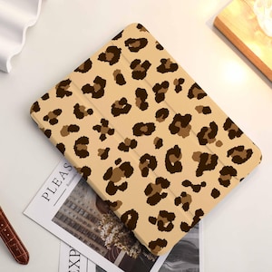 May include: A beige and brown leopard print iPad case. The case has a fold-over flap and a soft, textured finish.