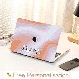 May include: A laptop skin with a pink, orange, and white abstract design. The skin features the text "Rachel H" in a handwritten font. The skin is designed to fit a laptop computer.