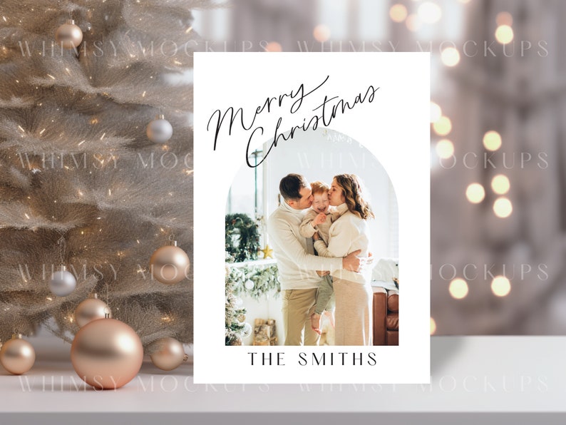 May include: A white Christmas card with a photo of a family of three. The parents are kissing their child on the cheek. The card has the text "Merry Christmas" and "The Smiths" printed on it.