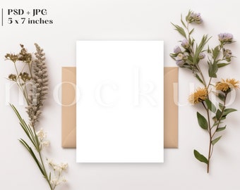 Puede incluir: Una tarjeta blanca en blanco con un sobre marrón, rodeada de flores secas y ramitas de vegetación sobre un fondo blanco. La tarjeta mide 12,7x17,8 cm.