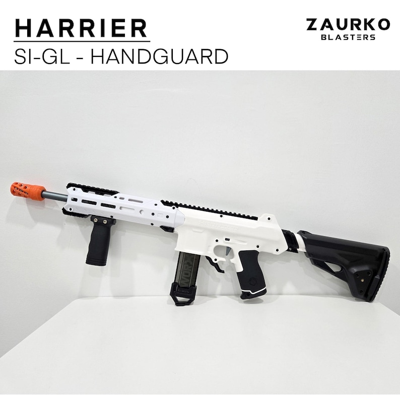 Puede incluir: Una pistola de juguete blanca y negra con una culata negra y un guardamanos negro. La pistola tiene un ca&ntilde;&oacute;n blanco y un cargador negro. La pistola est&aacute; etiquetada con "HARRIER SI-GL - HANDGUARD" y "ZAURKO BLASTERS".