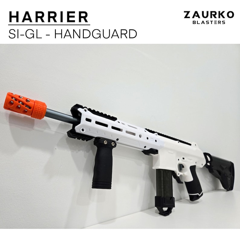 Puede incluir: Una pistola de juguete blanca y negra con un ca&ntilde;&oacute;n naranja y una empu&ntilde;adura negra. La pistola tiene un cargador negro y una culata negra. La pistola est&aacute; etiquetada con "HARRIER SI-GL - HANDGUARD" y "ZAURKO BLASTERS".