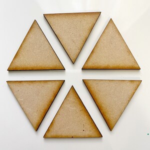 Op de afbeelding: Zes onafgewerkte houten driehoeksvormen in een cirkelvormige opstelling op een witte achtergrond.
