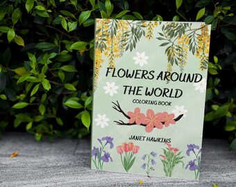 May include: A green and white coloring book with the title "Flowers Around The World Coloring Book" and the author's name "Janet Hawkins". The cover features colorful illustrations of flowers.