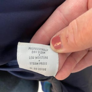 Peut inclure: Une tasse en c&eacute;ramique blanche avec une anse noire et le texte "But First, Coffee" en gras noir. La tasse est pos&eacute;e sur une surface en bois. La tasse mesure 10 cm de haut.