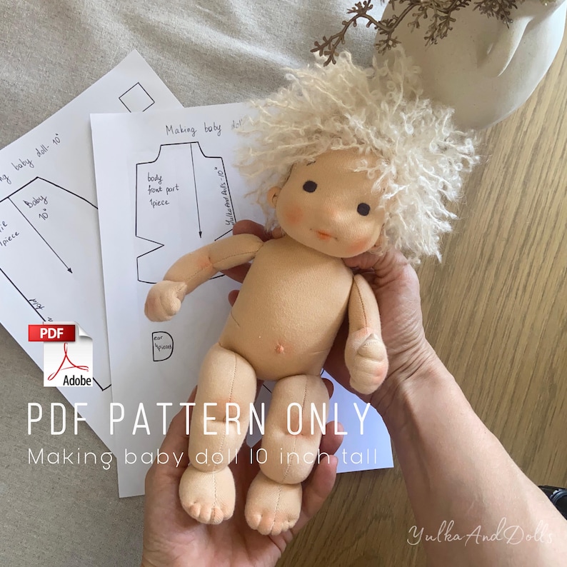 May include: A handmade baby doll with a cream-colored body and curly blonde hair. The doll is approximately 10 inches tall. The image includes pattern instructions and the text "PDF PATTERN ONLY Making baby doll 10 inch tall."