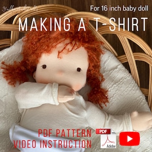 Puede incluir: Una muñeca hecha a mano con cabello rojo, vestida con una camiseta blanca y un pañal. La imagen incluye el texto "MAKING A T-SHIRT", "PDF PATTERN" y "VIDEO INSTRUCTION". La muñeca está diseñada para una muñeca de bebé de 40.6 cm.