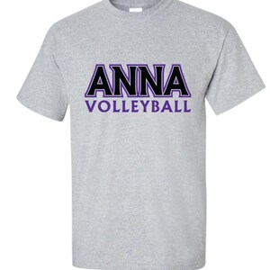 K&ouml;nnte beinhalten: Ein graues T-Shirt mit einer schwarzen und violetten Grafik, auf der "ANNA VOLLEYBALL" steht.