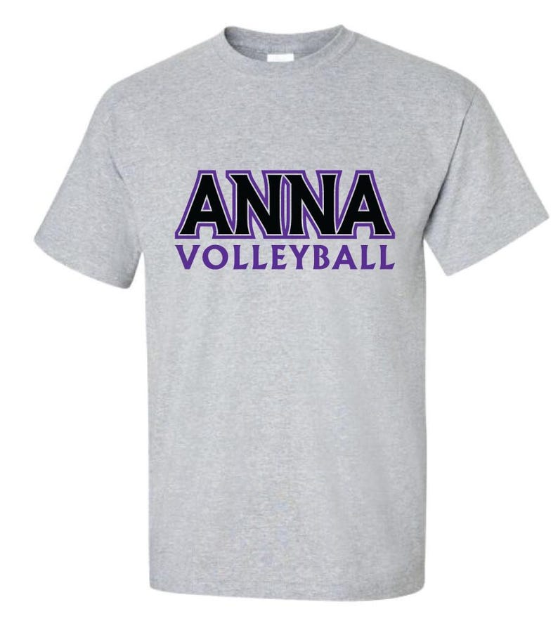 K&ouml;nnte beinhalten: Ein graues T-Shirt mit einer schwarzen und violetten Grafik, auf der "ANNA VOLLEYBALL" steht.