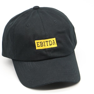 May include: A black baseball cap with a yellow rectangle on the front that says "EBITDA" in black lettering.