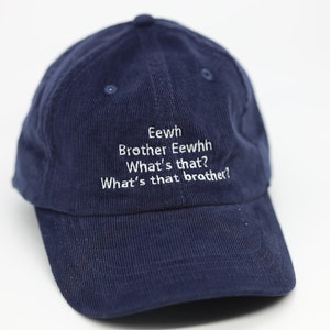 May include: A navy blue corduroy baseball cap with white embroidered text that reads "Eewh Brother Eewhh What's that? What's that brother?"