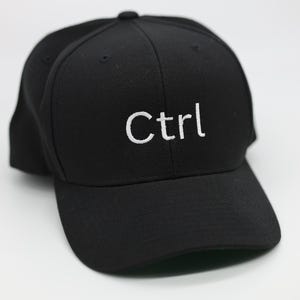 Op de afbeelding: Een zwarte baseballpet met een wit geborduurd "Ctrl" op de voorkant.