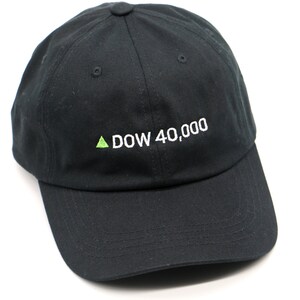 May include: A black baseball cap with a white embroidered arrow pointing upwards and the text "DOW 40,000".