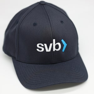 May include: A navy blue baseball cap with a white "svb" logo and a blue arrow.