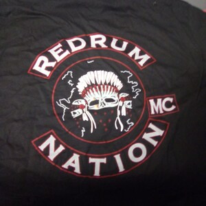 May include: Black t-shirt with a red and white patch that says "Redrum Nation MC" and features a skull wearing a headdress.