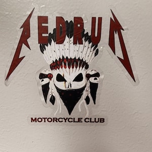 Puede incluir: Una pegatina roja y blanca con una calavera con un tocado y el texto "MEDRUM MOTORCYCLE CLUB".