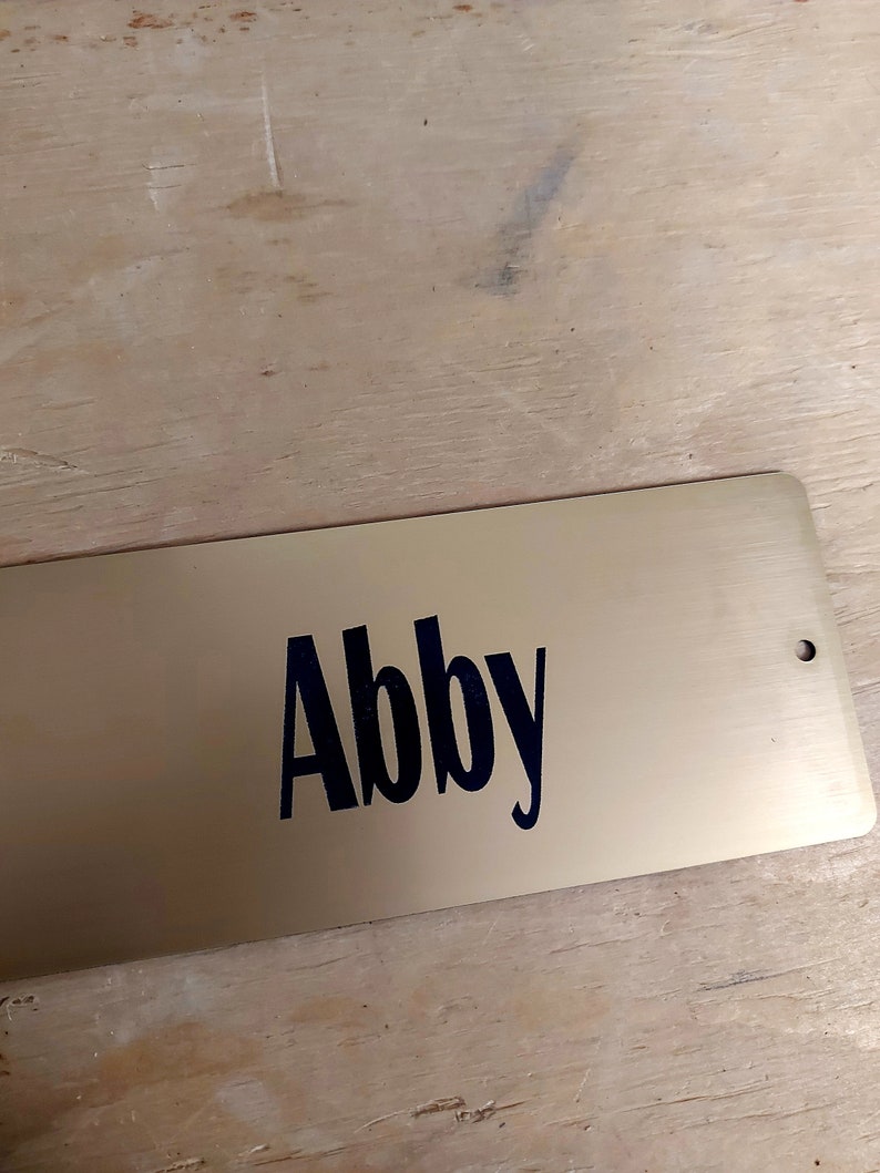 Gold plastic stall plate with black letters
