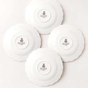 May include: Four white ceramic plates with scalloped edges, shown from the underside. Each plate features a central black stamp with a crown icon and the text MADE IN ENGLAND VINE & WHEAT A 8021, indicating the origin and collection details.