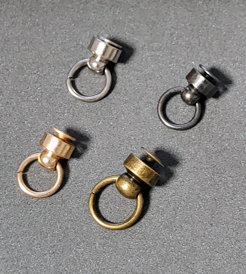 May include: Four swivel snap hooks in different finishes: silver, black, gold, and antique brass. Each hook has a small ring and a swiveling ball.