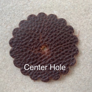 Leather rosette with center hole punched.