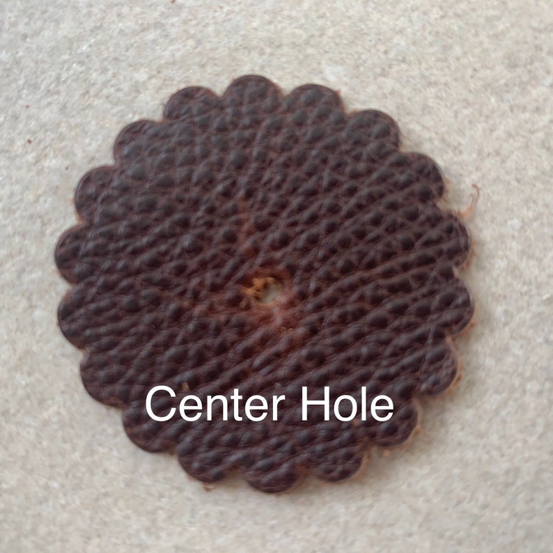 Leather rosette with center hole punched.