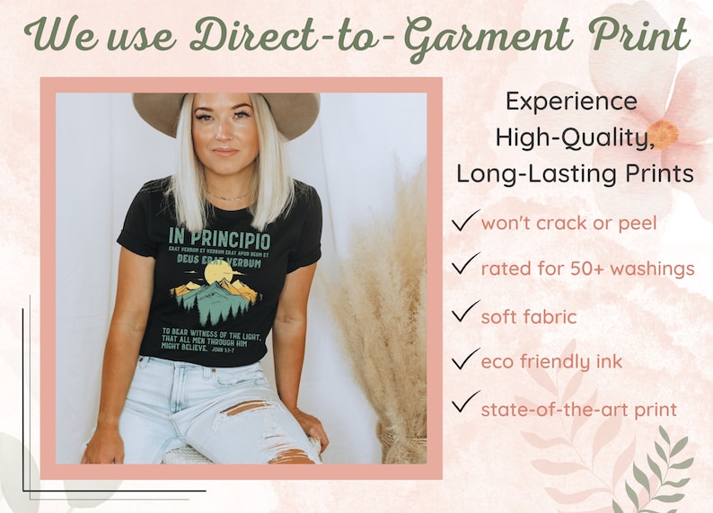 May include: Black t-shirt with a mountain graphic and the text "IN PRINCIPIO DEUS ERAT VERBUM". The image also includes text that says "We use Direct-to-Garment Print" and "Experience High-Quality, Long-Lasting Prints".