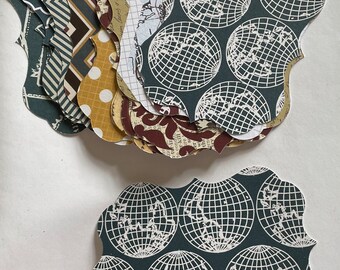 May include: A collection of decorative paper cutouts in various patterns and colors. Designs include geometric shapes, polka dots, and world map graphics. The cutouts are in a unique, scalloped shape.