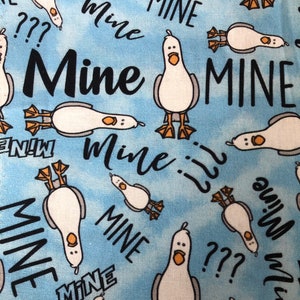 May include: A light blue fabric with a repeating pattern of cartoon seagulls and the word "Mine" in black. Some seagulls are upright, others are upside down. Question marks are also scattered throughout the design.