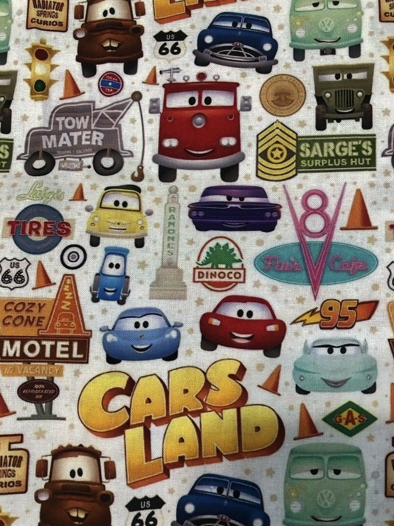 Pu&ograve; includere: Un tessuto colorato con tema Cars Land con vari personaggi del film Cars della Disney Pixar. Il tessuto presenta una variet&agrave; di auto, tra cui Mater, Saetta McQueen e altri personaggi. Il tessuto presenta anche vari cartelli e loghi, tra cui "Tow Mater", "Cozy Cone Motel", "Sarge's Surplus Hut" e "Cars Land".