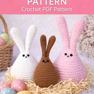 May include: Three crocheted Easter bunnies in white, brown, and pink, with black embroidered eyes and noses, sit on a bed of straw. Pastel-colored Easter eggs are in a basket and scattered around the bunnies. The image has the text "EASTER BUNNY PATTERN" and "Crochet PDF Pattern".