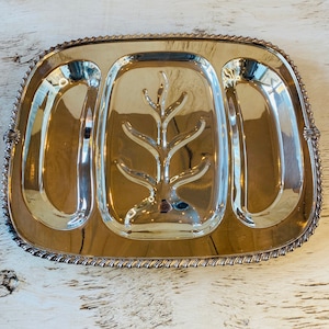 May include: A silver serving platter with three sections. The center section has a decorative tree design. The platter has a rope-like border.
