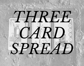 May include: Three tarot cards with the text "THREE CARD SPREAD" superimposed over them. The cards are the Magician, the Ace of Wands, and the Three of Pentacles.